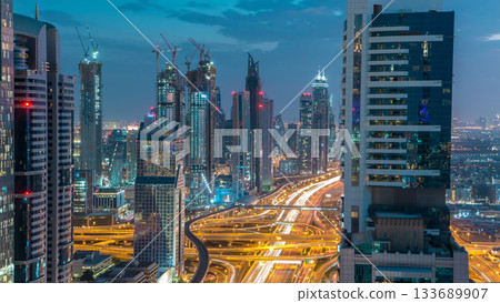Dubai downtown architecture day to night timelapse. Top view over Sheikh Zayed road with illuminated skyscrapers and traffic. 133689907