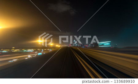 Front cabin POV view from modern driver-less metro train rush forward, along night Dubai, smooth timelapse. Front cabin POV view from modern driver-less metro train rush forward, along night Dubai, smooth timelapse. 133689910