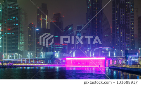 Illuminated Waterfall at the Sheikh Zayed Bridge timelapse, part of the Dubai Water Canal. Dubai, United Arab Emirates, Middle East 133689917