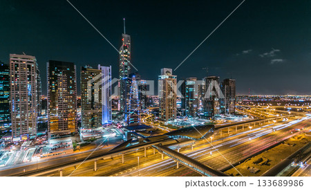 Buildings of Jumeirah Lakes Towers with traffic on the road night timelapse. 133689986