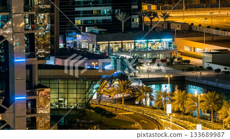 Buildings of Jumeirah Lakes Towers with traffic on the road night timelapse. 133689987