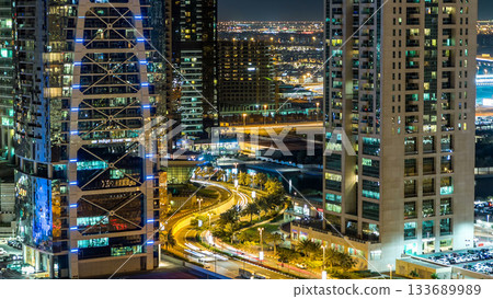 Buildings of Jumeirah Lakes Towers with traffic on the road night timelapse. 133689989