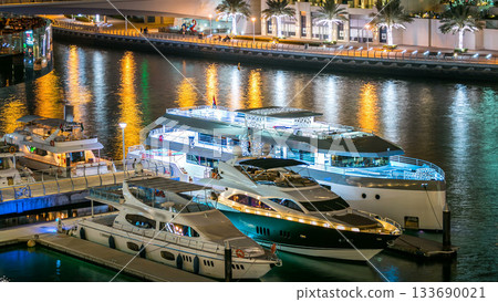 Dubai Marina towers and yachts in canal in Dubai night timelapse 133690021
