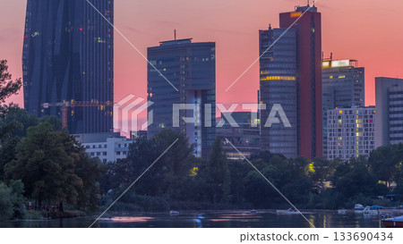 Vienna international center skyscrapers with Kaiserwasser lake reflection view day to night timelapse 133690434
