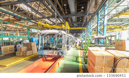 Conveyor assembly stage the body of tractor at big industrial factory timelapse Conveyor assembly stage the body of tractor at big industrial factory timelapse 133690451