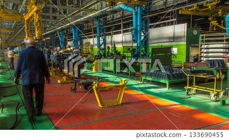 Conveyor assembly stage the body of tractor at big industrial factory timelapse Conveyor assembly stage the body of tractor at big industrial factory timelapse 133690455