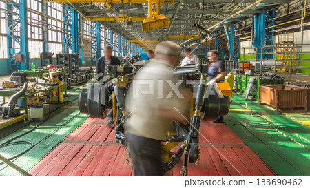 Conveyor assembly stage the body of tractor at big industrial factory timelapse Conveyor assembly stage the body of tractor at big industrial factory timelapse 133690462