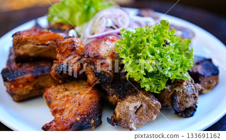 Spicy hot grilled spare pork ribs. Barbecue meat. Black background. Top view Spicy hot grilled spare pork ribs. Barbecue meat. Black background. Top view 133691162