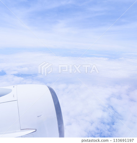 Daytime view of the sky and clouds above from an airplane window 133691197