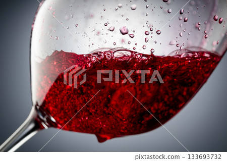 Red wine is poured into a glass. Red wine is poured into a glass. 133693732