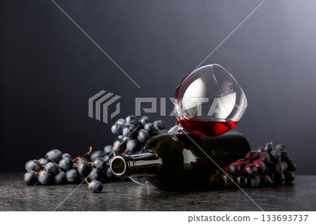 Grapes and red wine on a black background. 133693737