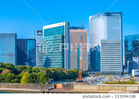 Tokyo cityscape in Japan: View of the Shiodome buildings and the former Tsukiji Market (6) including the temporary access road and removal of the upper structure of the loading pier 133694196