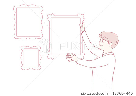 Man hanging frames on wall Man hanging frames on wall 133694440