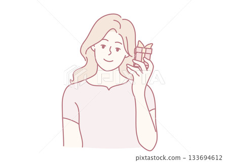 smiling woman savoring delightful chocolate bar, happy woman relishing tasty chocolate snack in casual surroundings, woman smiles joyfully while holding chocolate bar in relaxed environment smiling woman savoring delightful chocolate bar, happy woman relishing tasty chocolate snack in casual surroundings, woman smiles joyfully while holding chocolate bar in relaxed environment 133694612