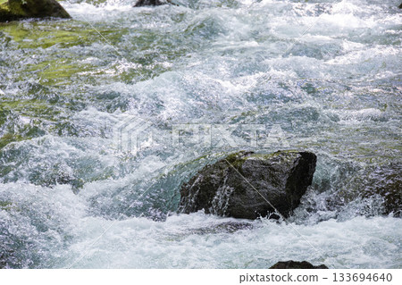 A rough river washing over the rock face A rough river washing over the rock face 133694640