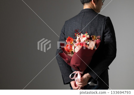 A man holding a bouquet (rear view) 133694793