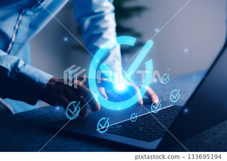 Digital approval concept with glowing checkmark icon on laptop screen, representing task completion, project validation, and goal achievement. Digital approval concept with glowing checkmark icon on laptop screen, representing task completion, project validation, and goal achievement. 133695194