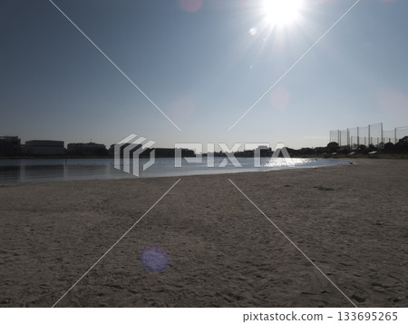 The wide sandy beach and canal at Omori Furusato no Hamabe Park bathed in strong sunlight The wide sandy beach and canal at Omori Furusato no Hamabe Park bathed in strong sunlight 133695265