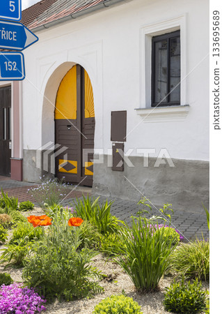 Village house with arched gate and directional signs Village house with arched gate and directional signs 133695689