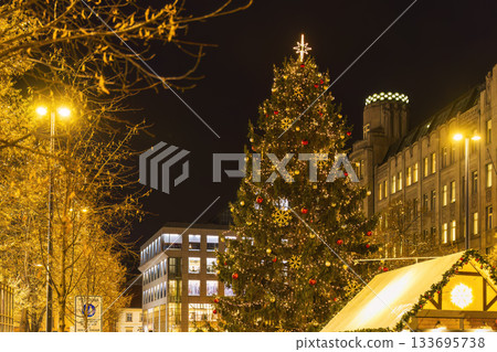 Christmas tree glowing in city square at night 133695738