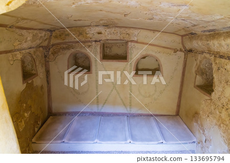 Roman burial chamber interior displaying ancient frescoes in Carmona, SPAIN 133695794