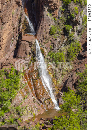 Water flowing among red rocks and green vegetation in Guillaumes Water flowing among red rocks and green vegetation in Guillaumes 133695830