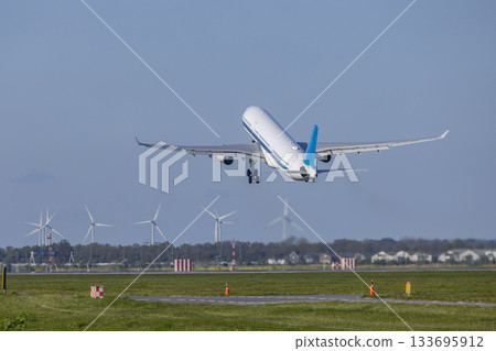Passenger airplane taking off near wind turbines in Vijfhuizen Passenger airplane taking off near wind turbines in Vijfhuizen 133695912