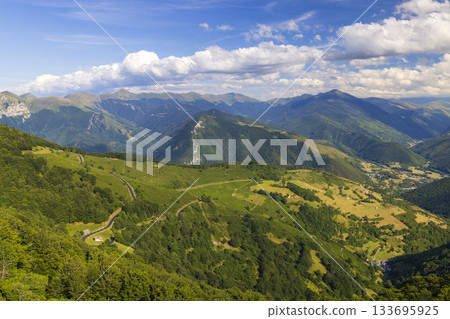 Col d'Aspin winding road among green Pyrenees mountains 133695925