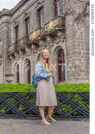 Young woman tourist standing near Chapultepec Castle in Mexico City, exploring the historic landmark. Solo travel, cultural heritage, tourism, and adventure concept 133696419