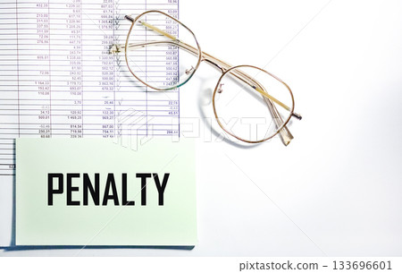 Close-up of the penalty notice on a sticker surrounded by business supplies Close-up of the penalty notice on a sticker surrounded by business supplies 133696601