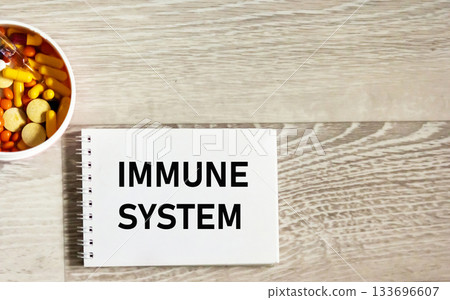 The inscription "IMMUNE SYSTEM" on the notebook next to the pills. Medical concept The inscription "IMMUNE SYSTEM" on the notebook next to the pills. Medical concept 133696607