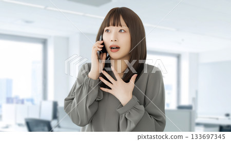 A woman/businesswoman surprised while talking on her smartphone 133697345
