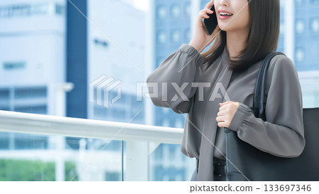 Smiling woman/businesswoman talking on smartphone 133697346