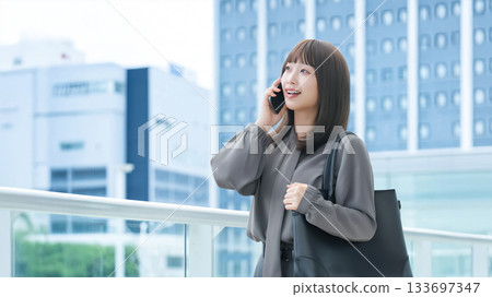 Smiling woman/businesswoman talking on smartphone 133697347