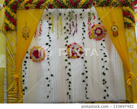 Beautiful wedding stage with plastic leaves and flowers. elegant indian wedding stage decoration background. tent for conference, wedding and party Beautiful wedding stage with plastic leaves and flowers. elegant indian wedding stage decoration background. tent for conference, wedding and party 133697482