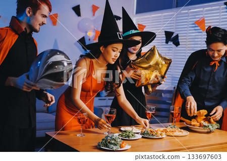 Joyful office Halloween party with coworkers in costumes, celebrating with drinks and laughter, fostering teamwork and festive spirit 133697603