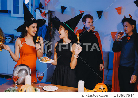 Joyful office Halloween party with coworkers in costumes, celebrating with drinks and laughter, fostering teamwork and festive spirit 133697614