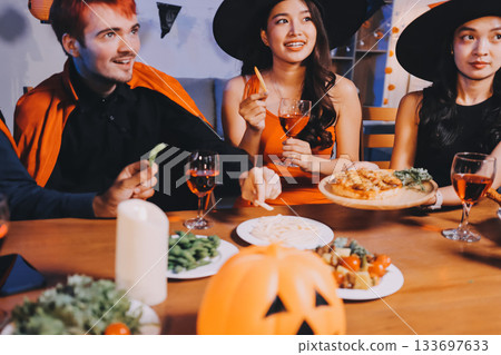 Joyful office Halloween party with coworkers in costumes, celebrating with drinks and laughter, fostering teamwork and festive spirit 133697633
