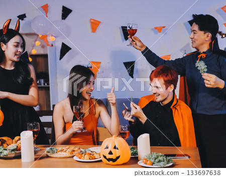 Joyful office Halloween party with coworkers in costumes, celebrating with drinks and laughter, fostering teamwork and festive spirit 133697638