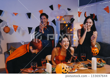 Joyful office Halloween party with coworkers in costumes, celebrating with drinks and laughter, fostering teamwork and festive spirit 133697644
