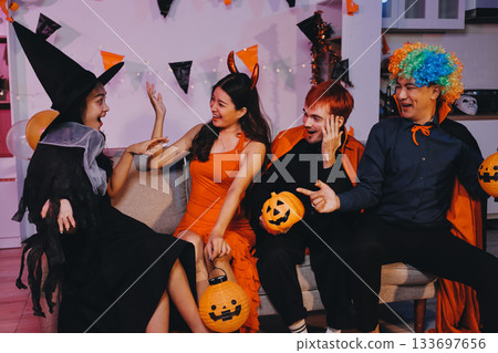 Joyful office Halloween party with coworkers in costumes, celebrating with drinks and laughter, fostering teamwork and festive spirit 133697656