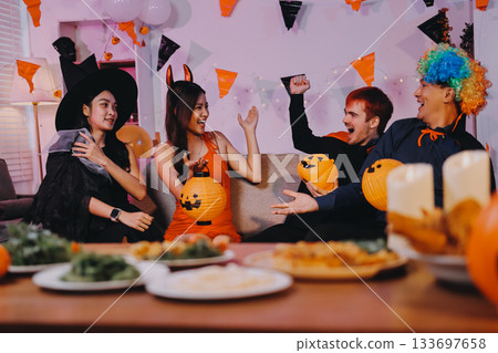 Joyful office Halloween party with coworkers in costumes, celebrating with drinks and laughter, fostering teamwork and festive spirit 133697658
