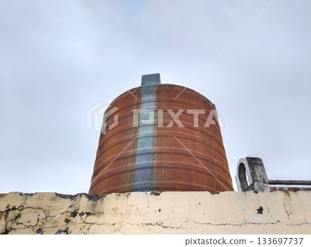 old plastic water tank on house roof 133697737