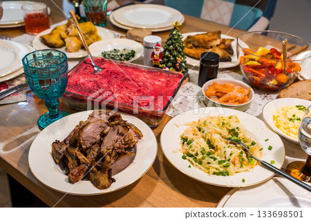Holiday table with herring under a fur coat salad and traditional homemade festive dishes 133698501