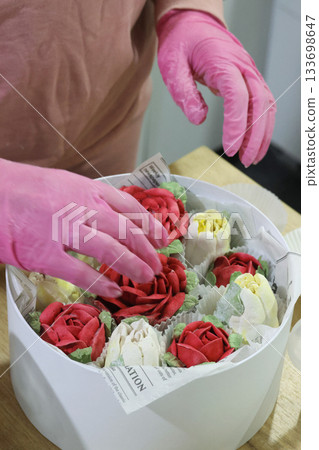 Female entrepreneur assembling marshmallow flowers in a hat box, marshmallow tulips and roses, homemade marshmallow 133698647