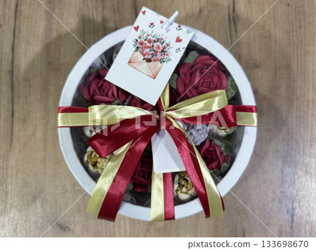 A hat box with homemade marshmallows, Tied with multicolored ribbons, Marshmallow roses and tulips, Greeting card, Top view 133698670