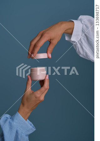 Hands opening cosmetic cream jar for skincare Hands opening cosmetic cream jar for skincare 133698717
