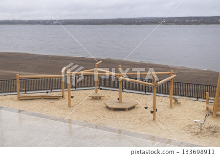 Children's playground on the bank of the river in winter Children's playground on the bank of the river in winter 133698911