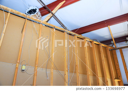Construction site exposed framing electrical wiring in building during renovation phase 133698977
