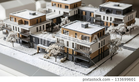 Detailed architectural model of a modern residential complex in winter. Real estate development and property investment concept. Miniature maquette of new housing covered in snow 133699601